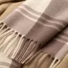 A brown checkered scarf pairs well with a beige coat for women in autumn and winter, providing warmth and fashion Application Scenario